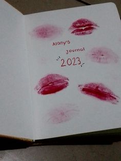 an open book with red lipstick imprints on the pages that read alony's journal 2013