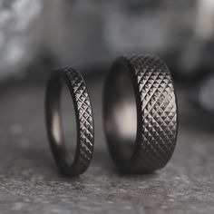 two wedding rings sitting next to each other on a table