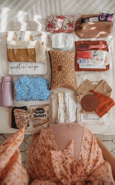 an assortment of clothing and accessories laid out on a bed