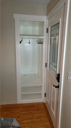 an empty walk in closet next to a white door