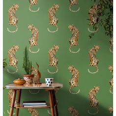 a green wall with leopard print on it and a plant in the corner next to it