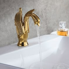 a golden faucet with water running from it's side in a bathroom