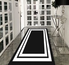 a large black and white rug in the middle of a room with glass doors on both sides