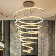 a modern chandelier hanging from the ceiling in a living room