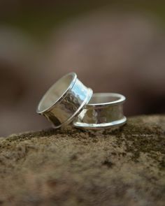 This simple and minimalist ring is a nice piece for everyday wear. It's wide enough to make a bit of statement on your hand without being annoying and bulky. The sides are sanded smooth to ensure a comfortable fit. This design was created for a man who wanted something toned down to go with his other celtic inspired, medieval and Viking/norse style rings - so if youre looking for a gift for him, something like this might work. It works great as a stackable ring with my other designs. If you're w Symbolic Silver Hammered Jewelry, Silver Symbolic Metal Rings, Minimalist Hand Forged Silver Stackable Rings, Adjustable Silver Viking Ring, Silver Brutalist Hammered Ring, Multiple Earrings, Multiple Rings, Viking Ring, Slow Fashion Movement