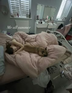 a dog laying on top of a bed under a pink blanket