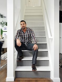 a man sitting on top of a set of stairs in front of a staircase case