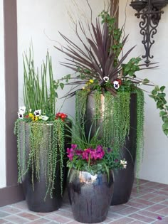 three large planters filled with different types of flowers