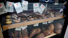 a display case filled with lots of different types of breads and muffins