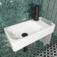 a white sink sitting next to a green tiled wall