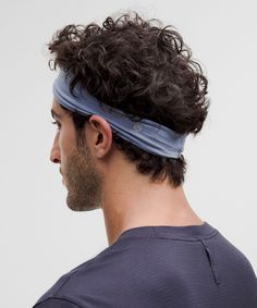 a man with curly hair wearing a headband