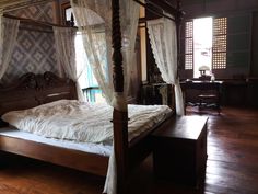 a four poster bed with white drapes on it