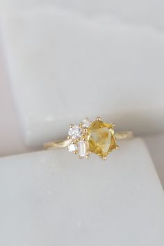 two yellow and white diamonds are on top of a gold ring