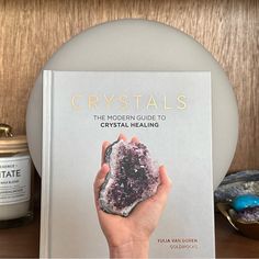 a book about crystals on a table next to some rocks and other items in front of it