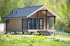 a small wooden cabin sitting on top of a lush green field