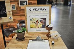 a wooden table topped with a clipboard next to a plant