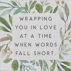 a white tile with green leaves and the words wrapping you in love at a time when words fall short