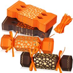 three boxes with orange ribbons tied around them and some chocolates in the middle one