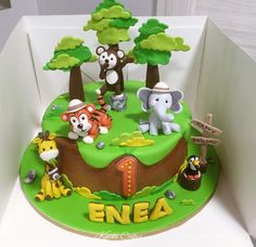 a birthday cake decorated with animals and trees