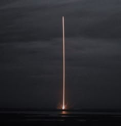 a spacex rocket launching into the night sky