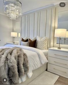 a bedroom with a bed, dressers and lamps on the side tables in front of it