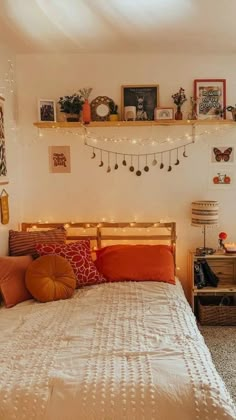 a bed room with a neatly made bed and lots of pictures on the wall above it