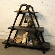 a shelf with books, vases and other items on it in front of a white brick wall