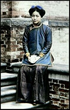 an old photo of a woman sitting on some steps