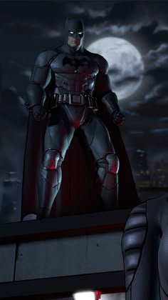 the animated batman is standing on top of a building at night with his cape up