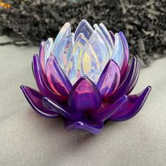 a purple glass flower sitting on top of a table