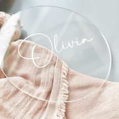 a glass plate with the name eliia written in white lettering on it and a pink blanket next to it