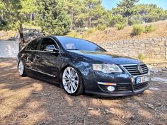 a black car parked in front of a stone wall