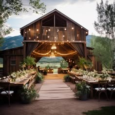 an outdoor barn with tables and chairs set up for a wedding reception in the evening