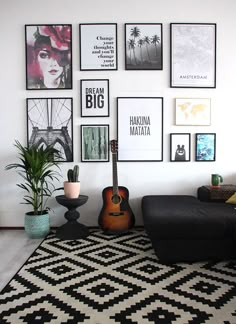 a living room with pictures on the wall and a guitar in front of a couch