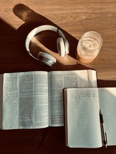 an open book and headphones on a table