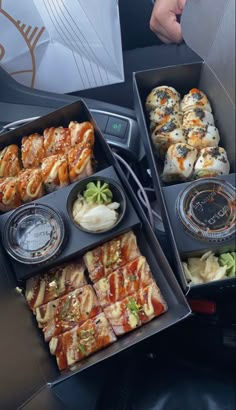 two boxes filled with different types of food on top of a black table next to each other