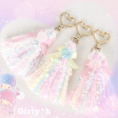 three little tassels with bows on them are hanging from a keychain