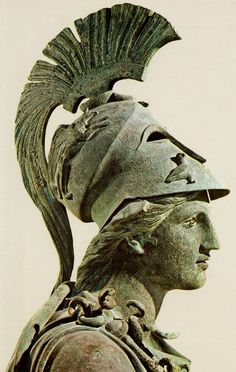 an ancient statue is wearing a helmet with feathers on it's head and hair in the shape of a feather