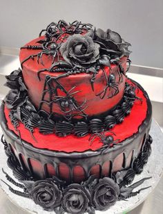 a red and black cake with spider decorations on it