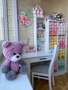 a teddy bear sitting on top of a white desk