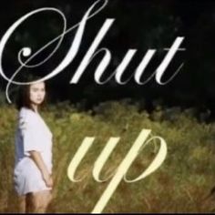 a girl standing in tall grass with the words shut up