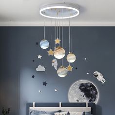 a child's bedroom with stars, moon and planets on the wall above the bed