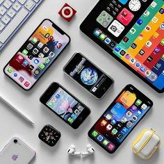 several different types of cell phones sitting on top of a table next to a keyboard