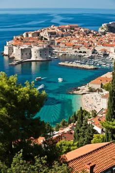 an aerial view of a city with boats in the water and red roofs on it