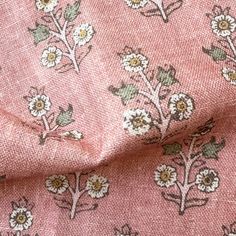 a pink fabric with white flowers on it