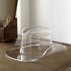 a clear plastic hat sitting on top of a wooden table