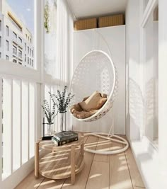 a white hanging chair in the corner of a room next to a table with a book on it