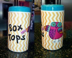 two coffee mugs with the words box tops painted on them sitting on a counter