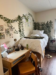 a bedroom with a bed, desk and plants on the wall