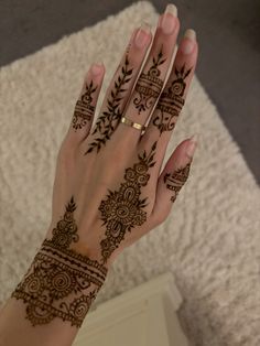 a woman's hand with henna tattoos on it